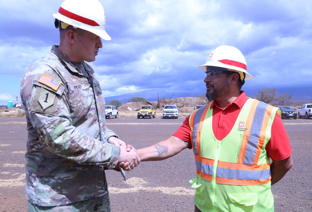 Lt. Col. Ryan C. Pevey, commander, Honolulu District, U.S. Army Corps of Engineers presents a coin to Anthony Cardona, the safety officer for the Honolulu District Power Planning and Response Team on Maui, Aug. 28. The USACE is working with local, state and federal partners on a mission assignment from the Federal Emergency Management Agency in response to the Hawai’i Wildfires.