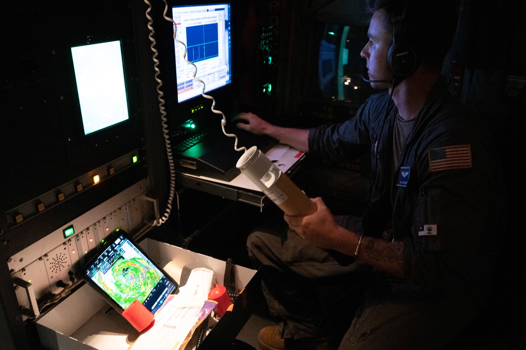 An Airman checks a dropsonde on an aircraft