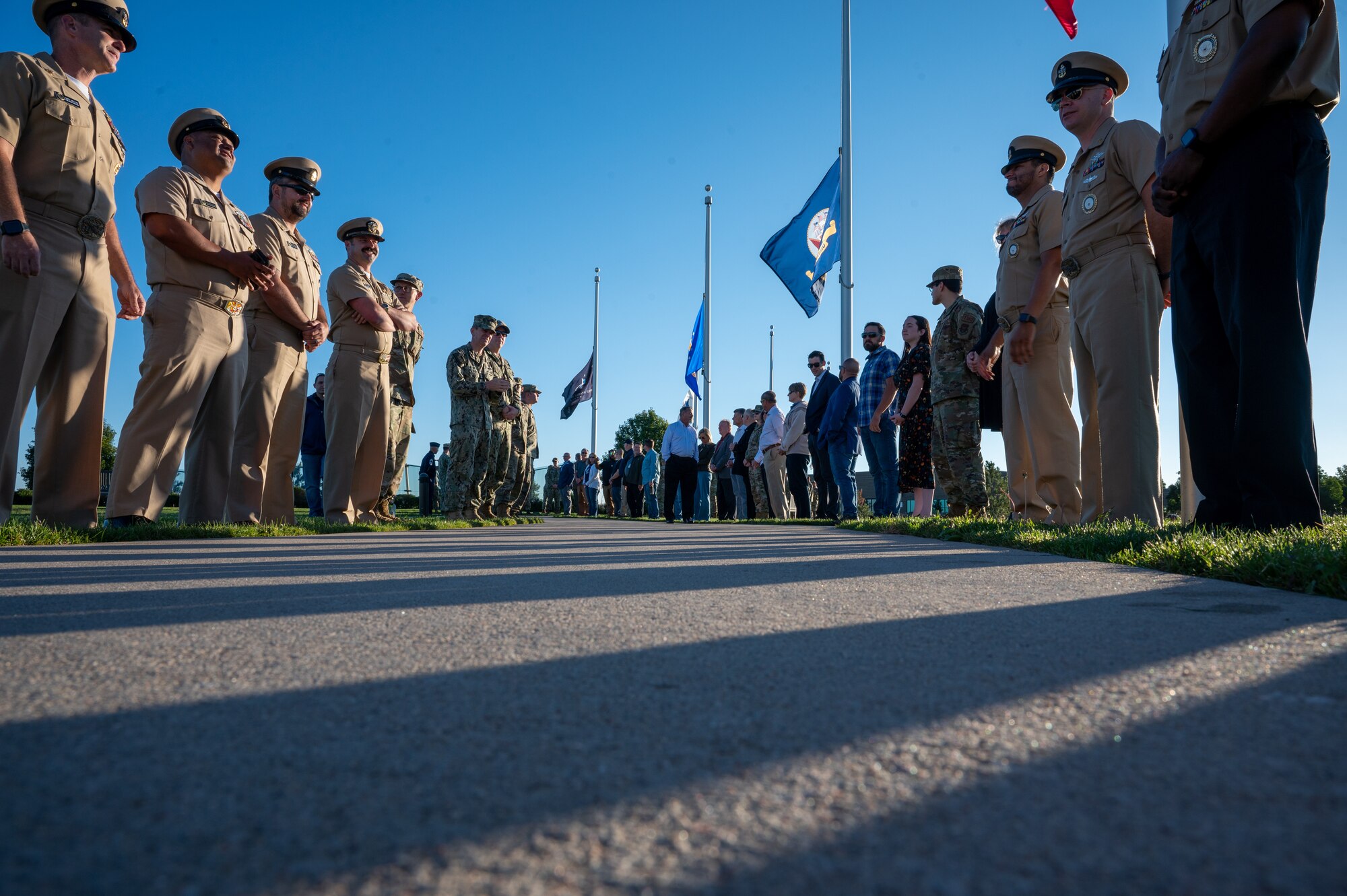 People stand in line on two sides of a sidewalk.