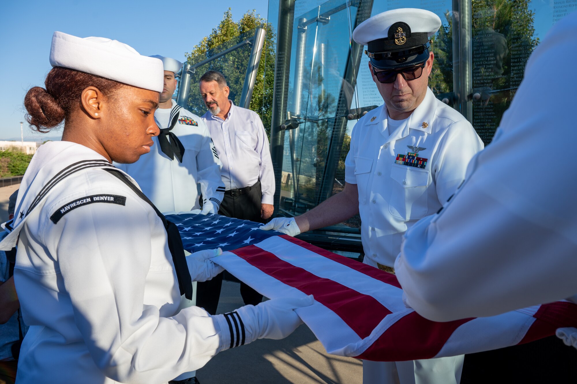 Sailors fold an American flag.