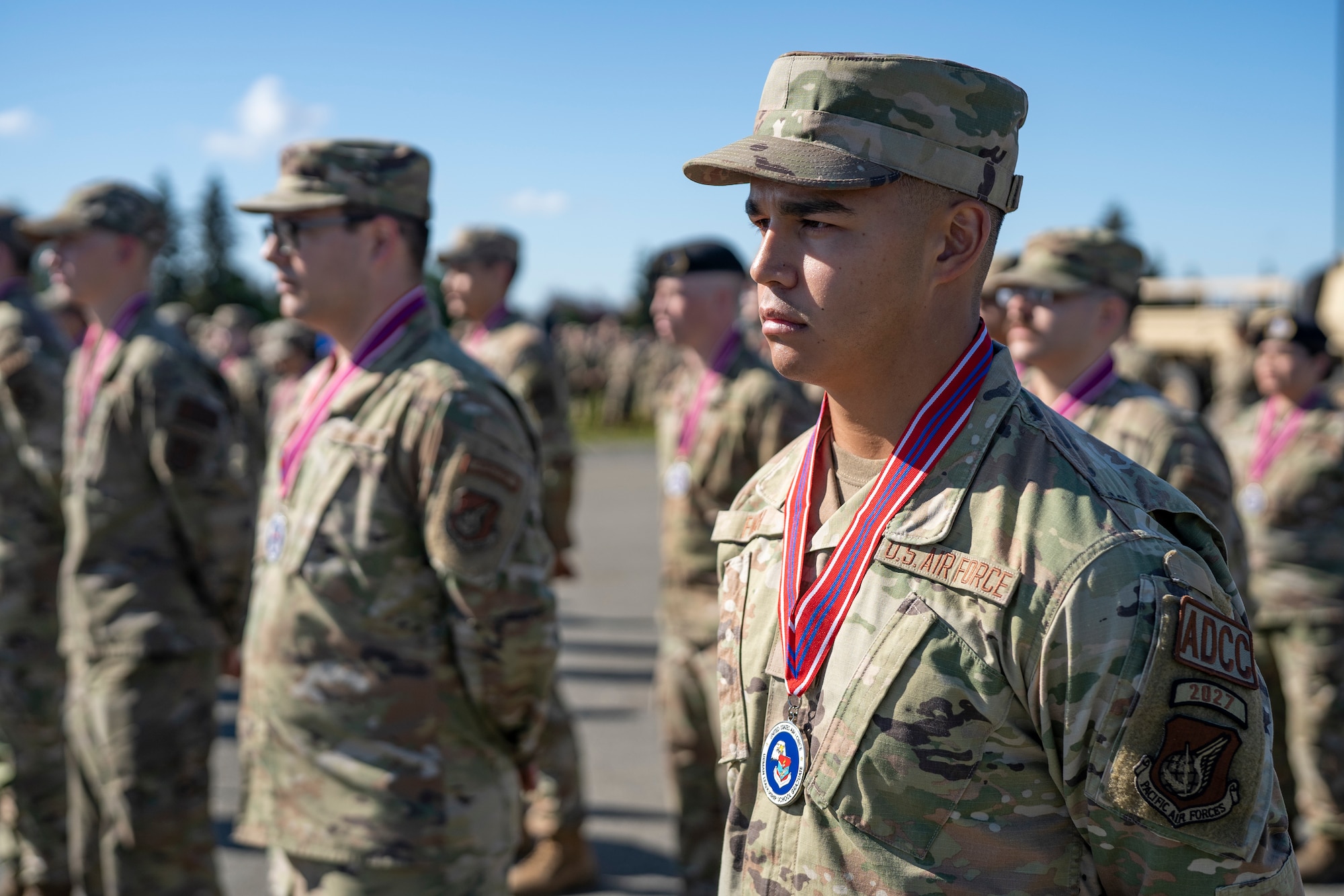 U.S. Air Force Senior Airman Christopher Finch stands at attention in a formation with his fellow Airmen.