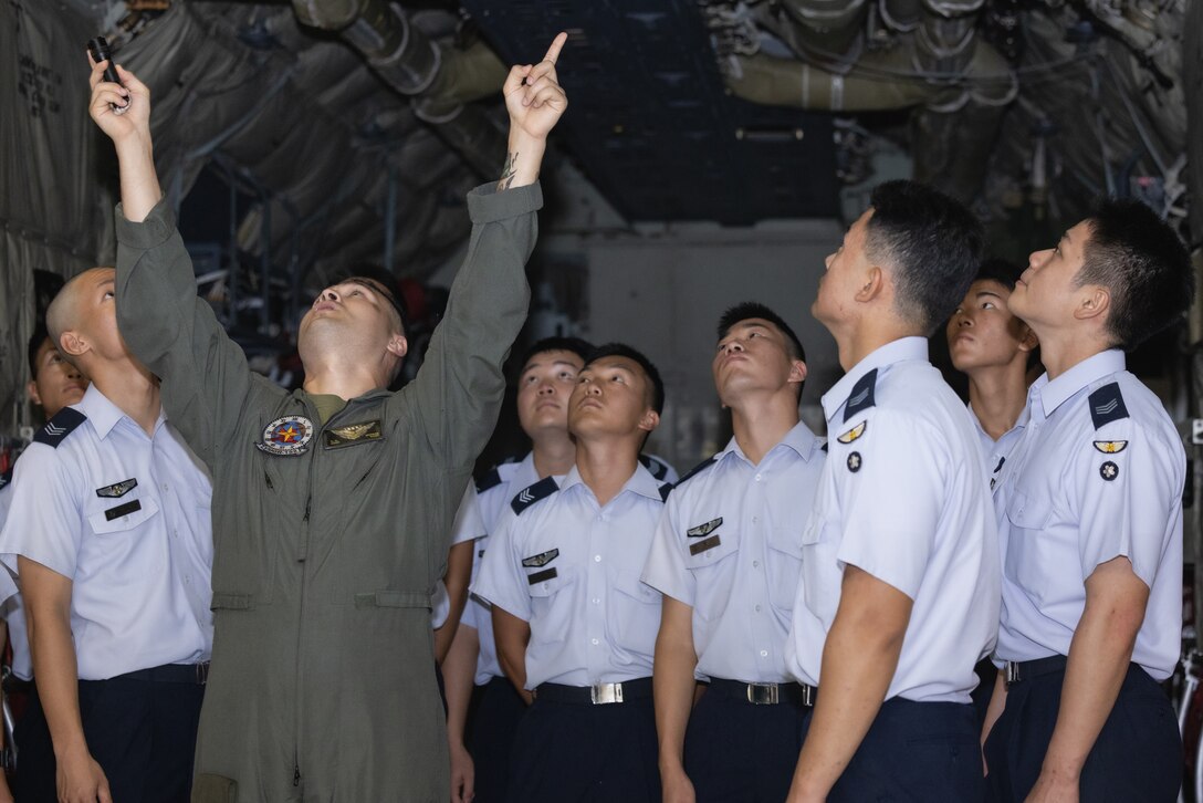 U.S. Marine Corps Staff Sgt. Roger Stuksa, a fixed-wing aircraft flight engineer with Marine Aerial Refueler Transport Squadron 152, Marine Aircraft Group 12, talks about KC-130J Super Hercules aircraft capabilities to Japan Air Self-Defense Force (JASDF) cadets during an installation tour at Marine Corps Air Station Iwakuni, Japan, Aug. 23, 2023. During the tour, JASDF cadets learned about the installation's capabilities and were shown various aircraft including the C-12 Huron, KC-130J Super Hercules, and the F-35B Lightning II. (U.S. Marine Corps photo by Cpl. Raymond Tong)
