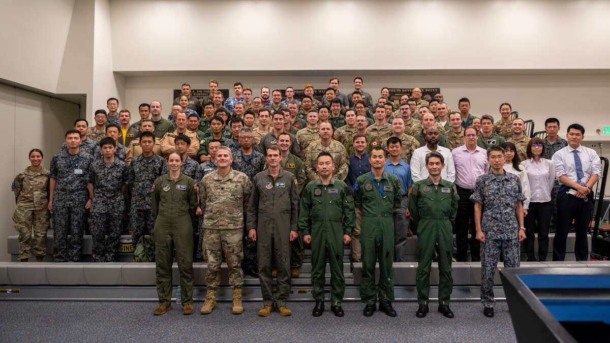 Attendees from the Japan Air Self Defense Force, British Royal Air Force, Royal Australian Air Force, and Canadian Armed Forces, pose for a group photo on the last day of the Far East Tactics Analysis Team conference at Yokota Air Base, Japan, July 28, 2023.