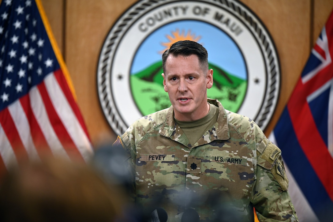 A man in an Army uniform speaks at a podium