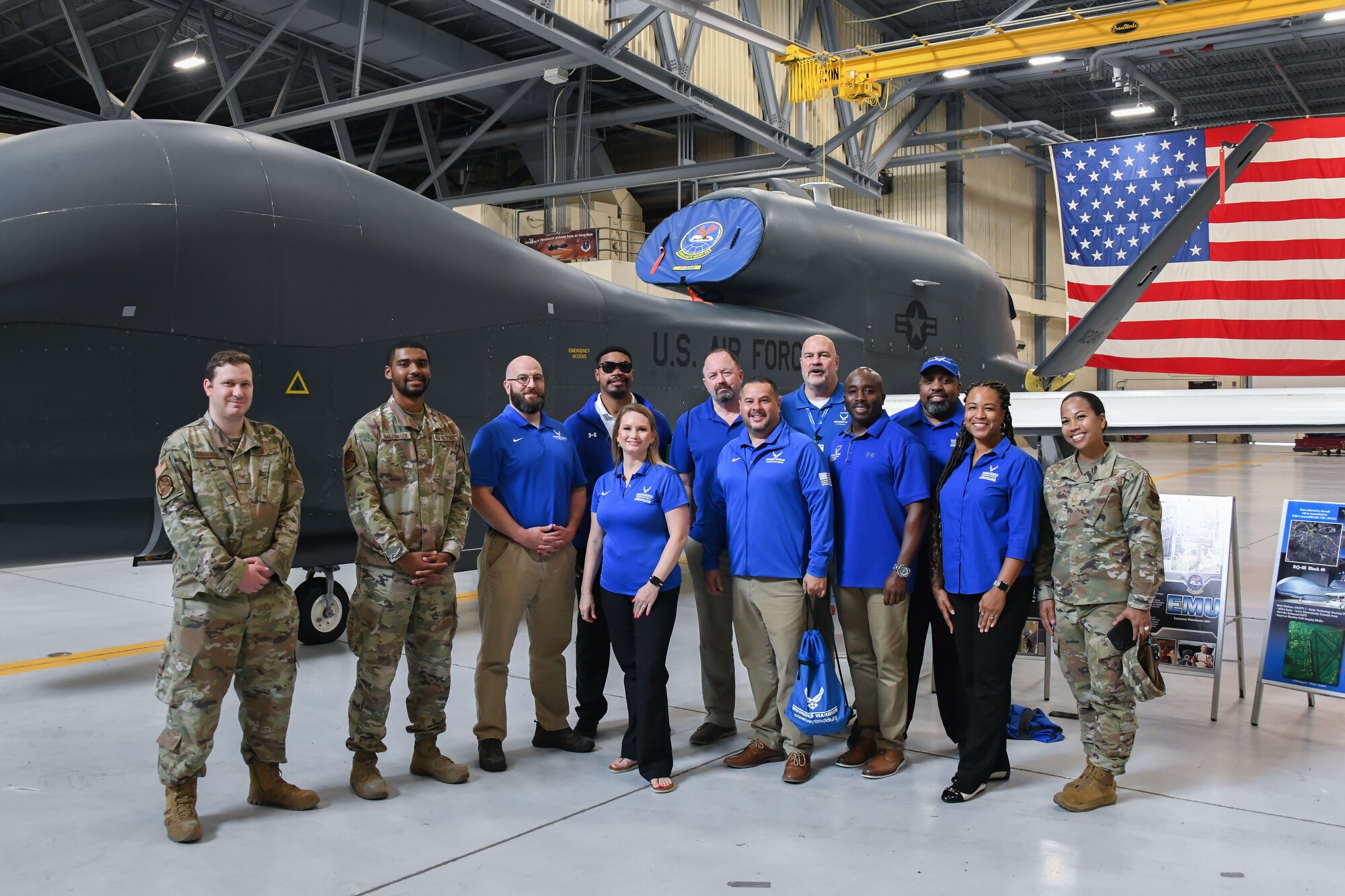 Ambassadors and Airmen pose next to an RQ-4