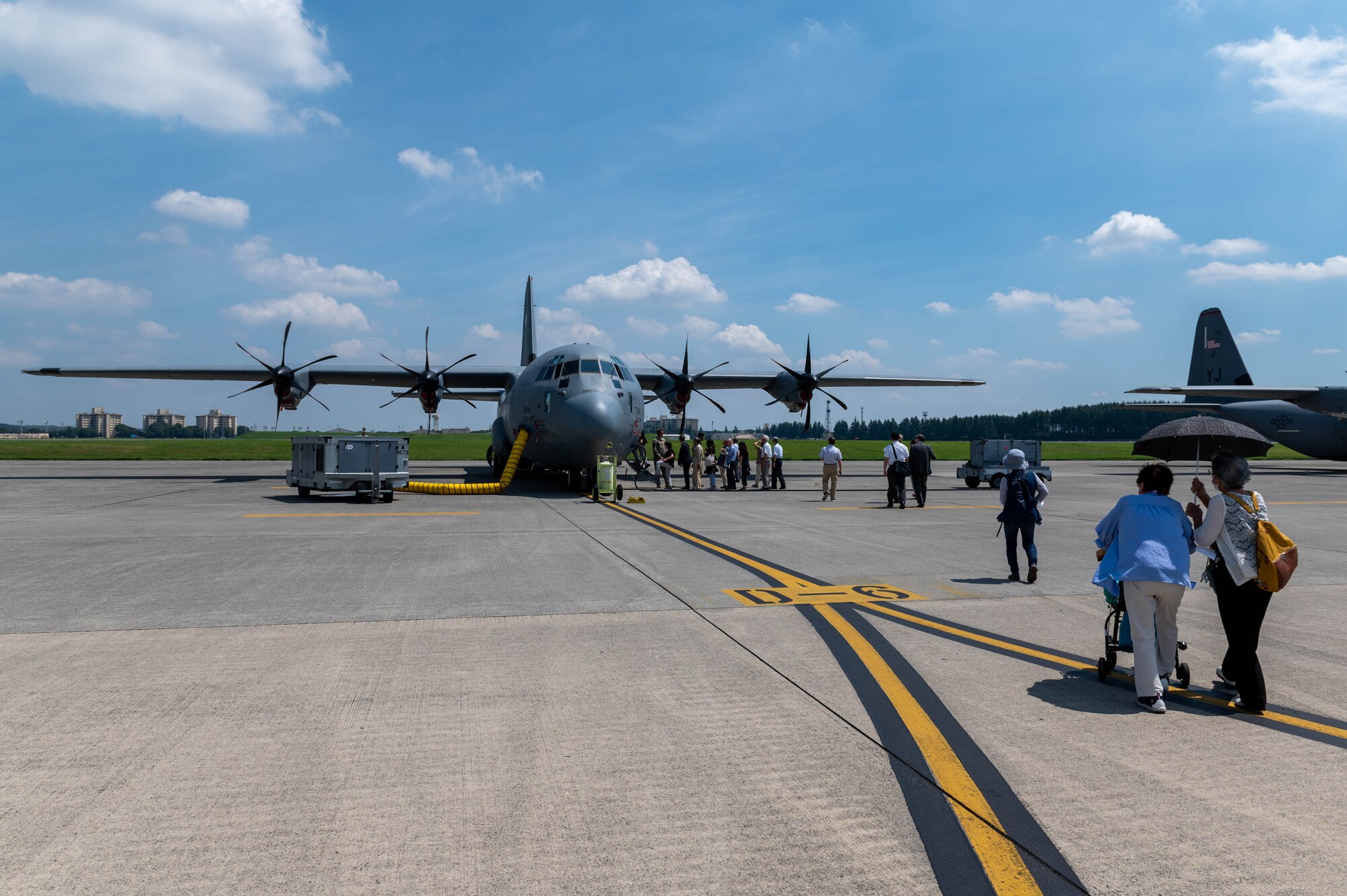 Japanese civilians walk toward a C-130J Super Hercules.