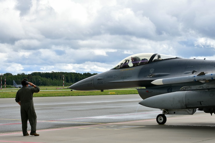 maintainer saluting a pilot in a jet