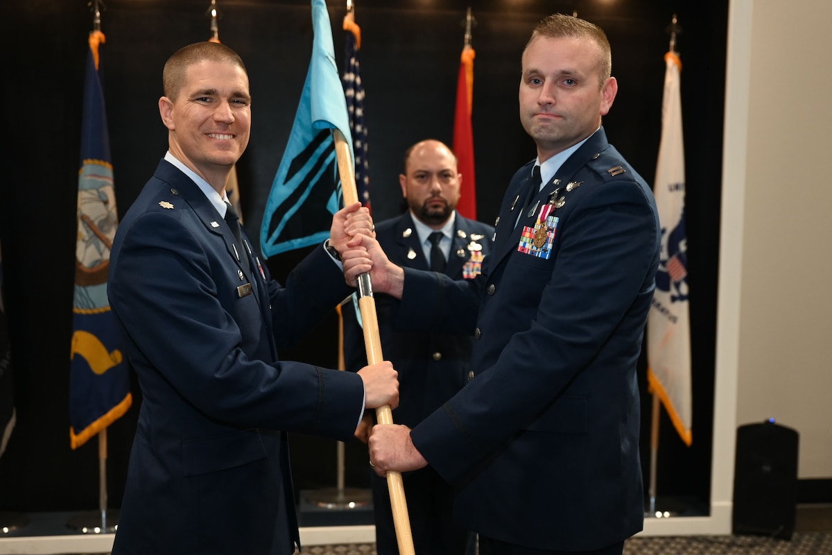 U.S. Space Force Lt. Col. Jonathan R. Arehart, left, 533rd Training Squadron commander, takes the 533rd TRS, Detachment 1 guidon from Cpt. Robert Freeman, right, departing commander, during the  533rd, Detachment 1 Change of Command Ceremony at the Powell Event Center, Goodfellow Air Force Base, Texas, Aug. 29, 2023. Freeman assumed command on June 21, 2022. (U.S. Air Force photo by Airman 1st Class Evelyn J. D’Errico)