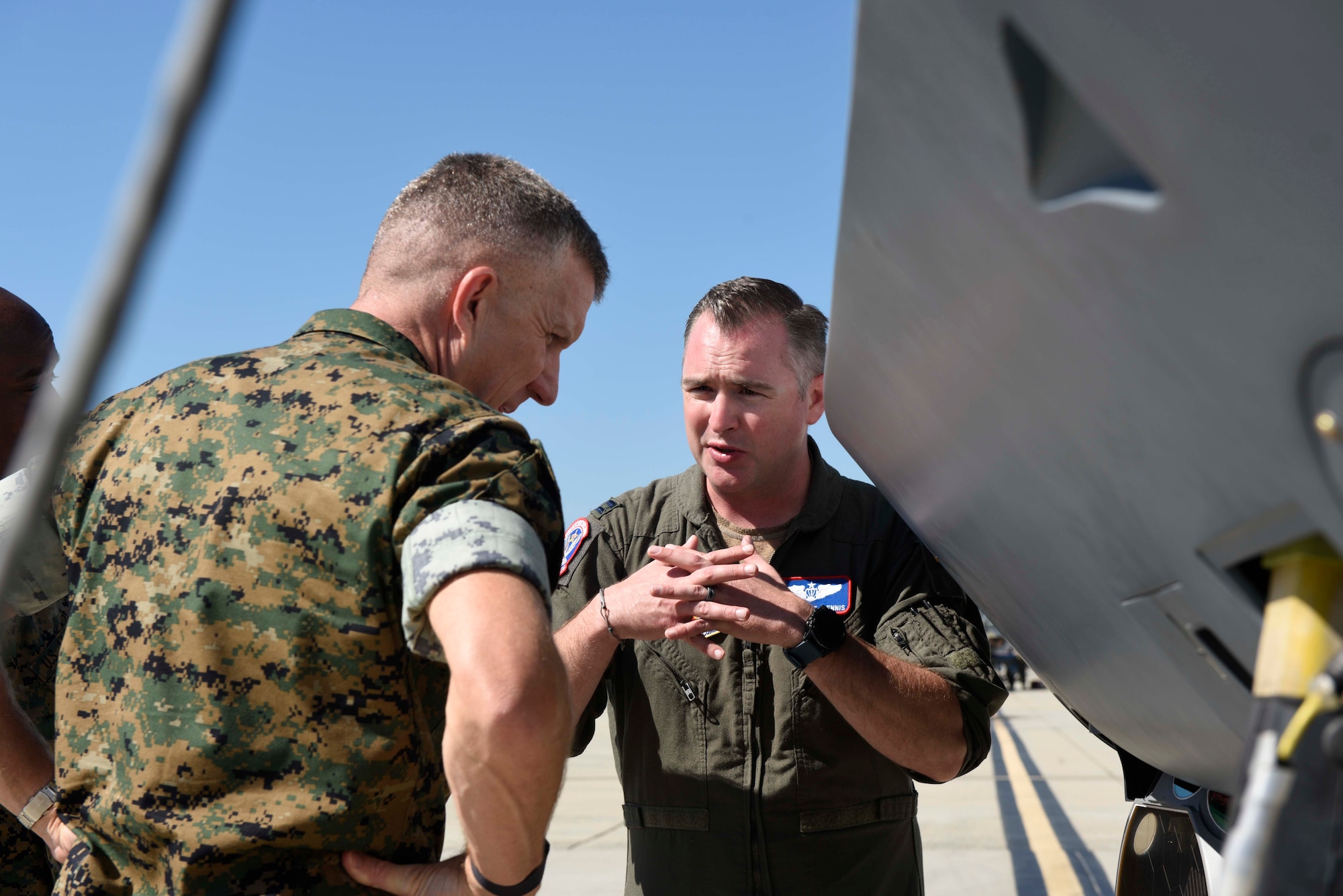 U.S. Air Force Capt. Joseph Dennis educates  U.S. Marine Corps Brig. Gen. Jason Woodworth about the MQ-9 Reaper remotely piloted aircraft while standing next to a MQ-9