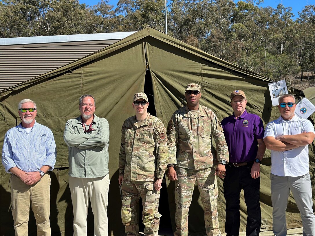 People standing in front of a tent.