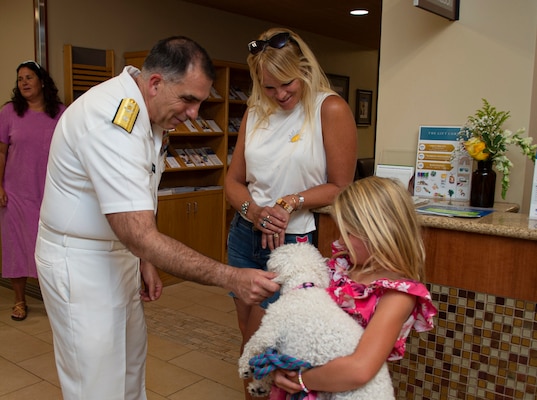 BILLINGS, Mont. (Aug. 11, 2023) Rear Adm. Matthew Case, commander, Naval Medical Forces Atlantic, pets a dog at the St. Vincent Foundation hospital before a round table discussion.