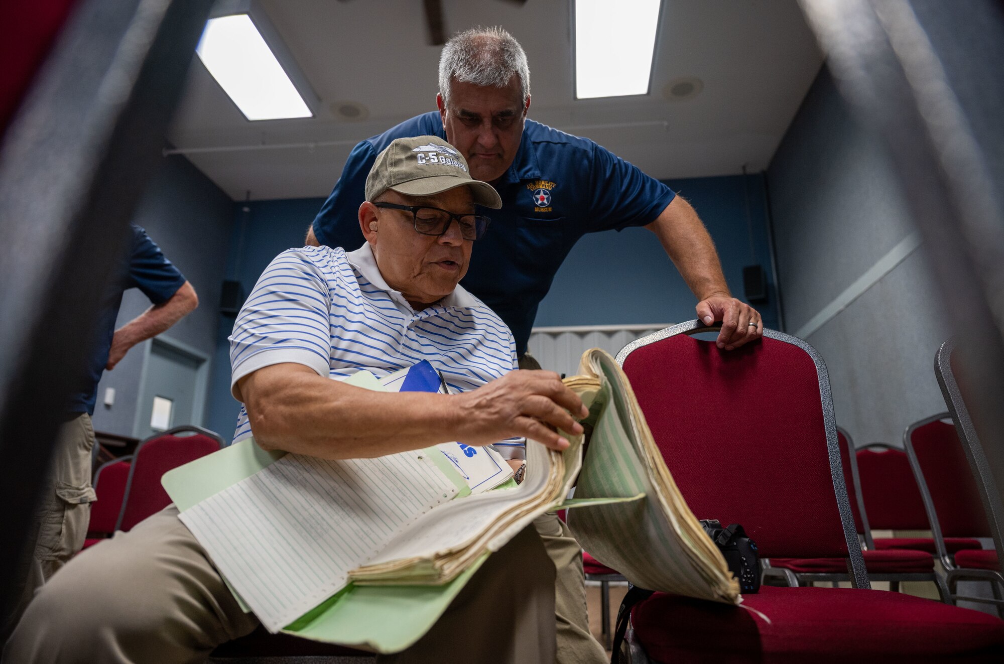 U.S. Air Force retired Lt. Col. William Jordan shows Michael Hulbert, Air Mobility Command Museum volunteer, his active duty flight logs at the AMC Museum on Dover Air Force Base, Delaware, Aug. 25, 2023. Jordan was the commander of the first all African American C-5A Galaxy mission in 1986 and provided the museum with historical documentation from his time spent on active duty. (U.S. Air Force photo by Airman 1st Class Amanda Jett)