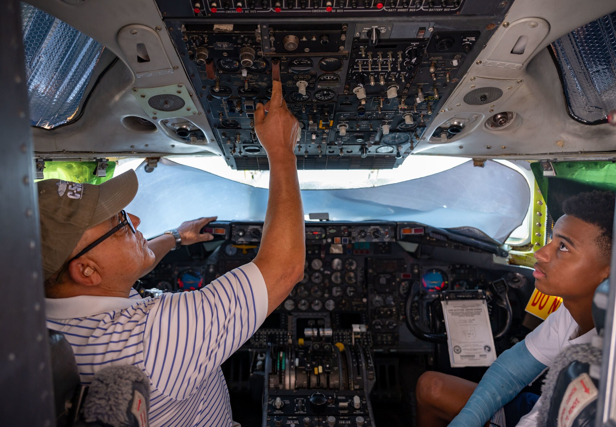 U.S. Air Force retired Lt. Col. William Jordan, left, points out controls to Jonathan Winston, right, his grandson, at the Air Mobility Command Museum on Dover Air Force Base, Delaware, Aug. 25, 2023. Jordan was the commander of the first all African American C-5A Galaxy mission in 1986 and provided the museum with historical documentation from his time spent on active duty. (U.S. Air Force photo by Airman 1st Class Amanda Jett)