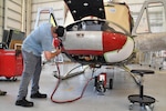 Sean Maher, an aircraft electrician on Fleet Readiness Center East’s (FRCE) UH-1N production line, connects a battery-powered ground power unit (GPU) while conducting checks on a UH-1N helicopter. FRCE’s UH-1N production line is swapping out diesel-powered GPUs for battery-powered GPUs, becoming the first adapter of this technology within the Naval Aviation community.