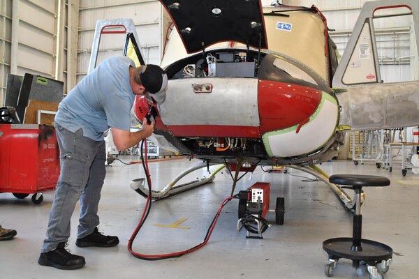 Sean Maher, an aircraft electrician on Fleet Readiness Center East’s (FRCE) UH-1N production line, connects a battery-powered ground power unit (GPU) while conducting checks on a UH-1N helicopter. FRCE’s UH-1N production line is swapping out diesel-powered GPUs for battery-powered GPUs, becoming the first adapter of this technology within the Naval Aviation community.
