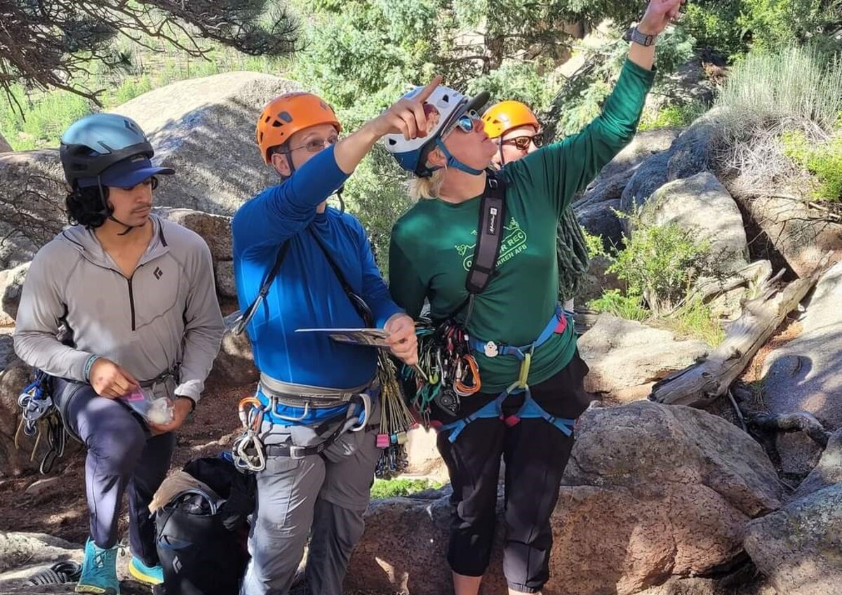 participants point to different approaches on a rock face