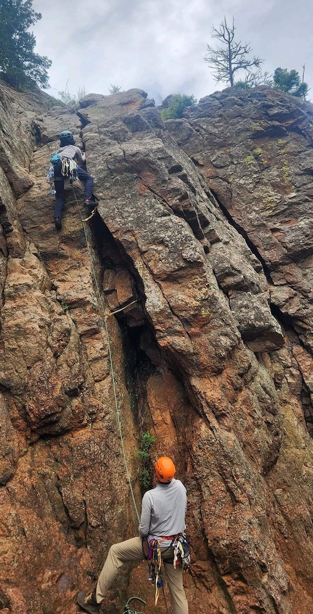 two participants on the face of a rock