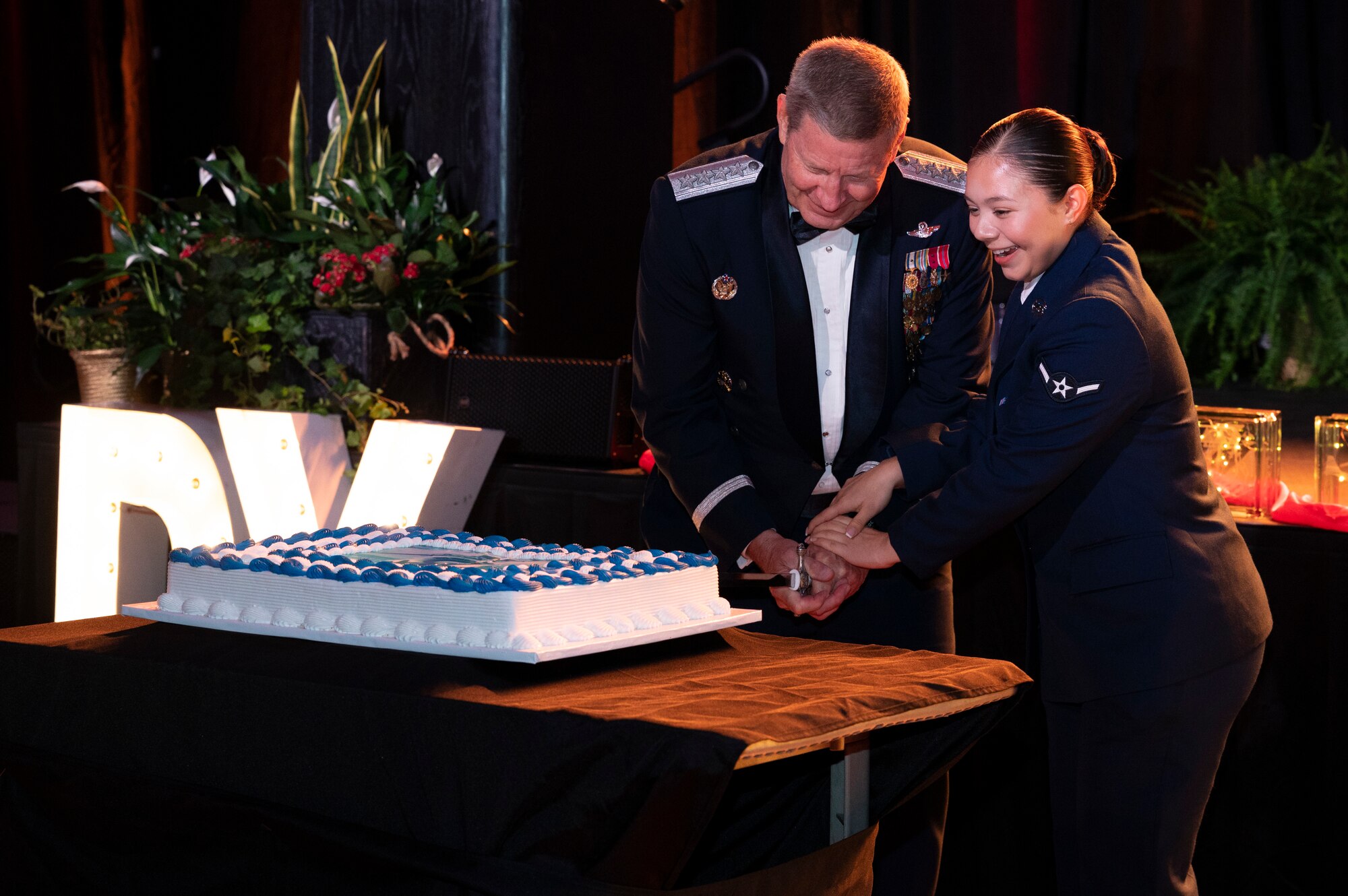 Retired  Gen. Robin Rand, former Air Force Global Strike Command and Air Forces Strategic Air, U.S. Strategic Command, commander, and Airman Sharon Valez  Tobon, 317th Operation Support Squadron  aircrew flight equipment technician, cut the ceremonial cake during the Abilene Military Affairs Committee and Dyess Air Force Gala in Abilene, Texas, Aug. 26, 2023. Air Force tradition is for the lowest ranking and highest ranking Airmen to cut the official cake for the ceremony.