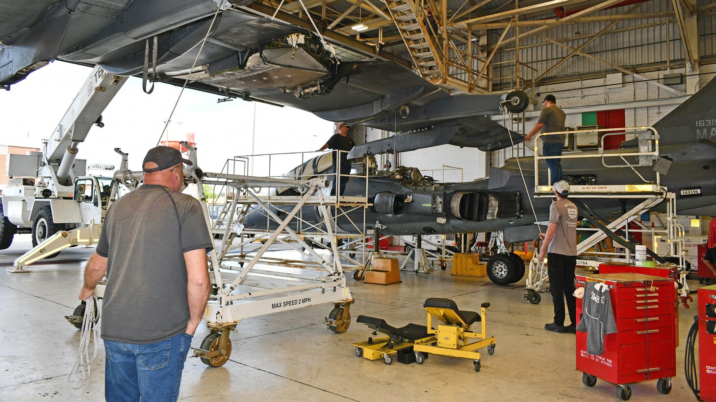 Aircraft maintenance professionals on the Fleet Readiness Center East (FRCE) Harrier production line prepare to reattach the wing to the last TAV-8B Harrier trainer to be completed at the facility.