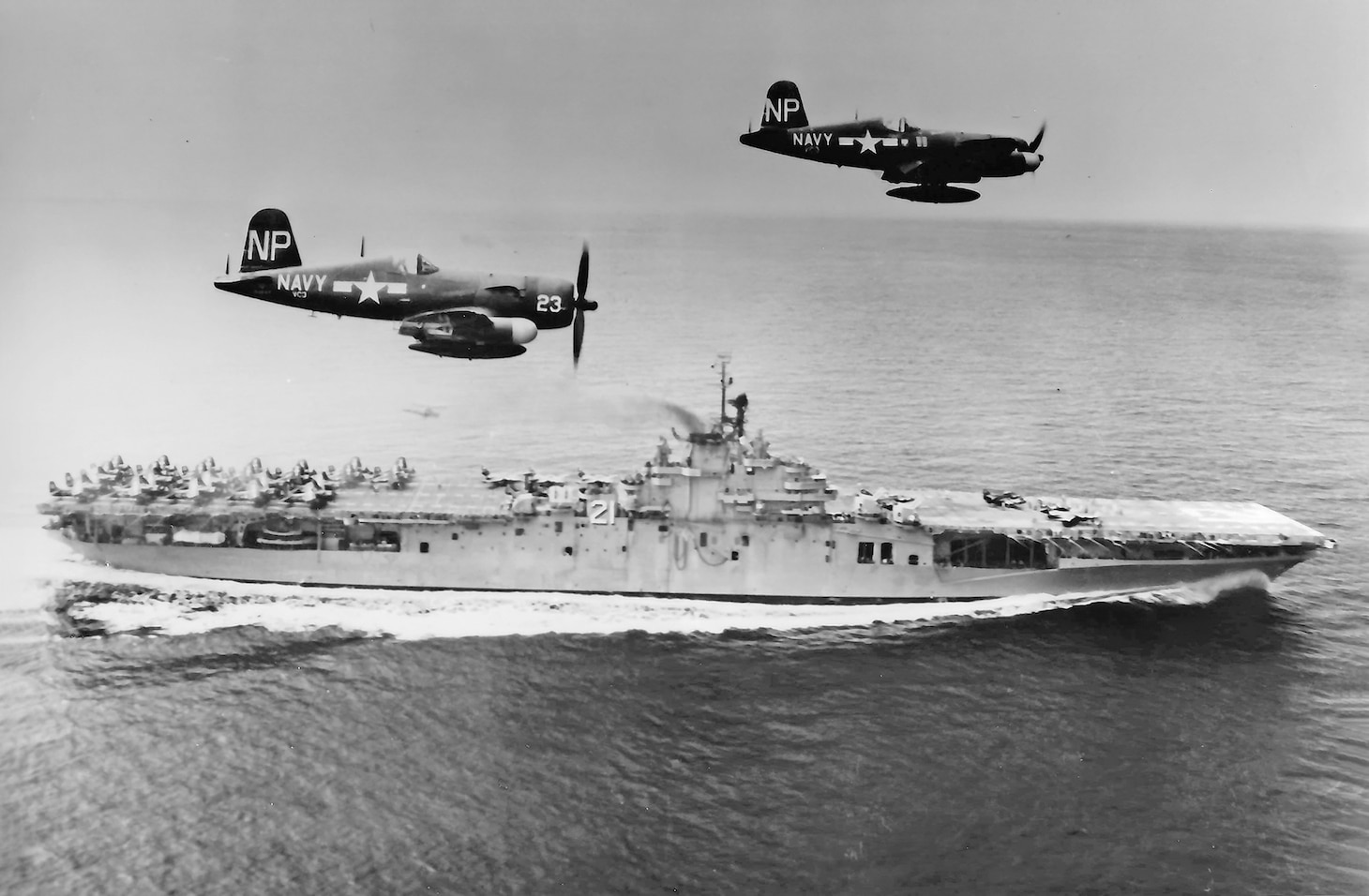 F4U-5N Corsairs of VC-3 return from a mission to the USS Boxer (CV 21) on Sept. 4, 1951. The carrier joined operations with Task Force 77 in March 1951 with the first Naval Air Reserve squadrons to fly strikes during the Korean War, most of which were strikes against Chinese ground forces along the 38th Parallel. This model of the long-lived Corsair was a night fighter and its missions were often after dark against enemy supply lines, truck convoys and trains, using napalm, various iron bombs and unguided rockets. Note the aircraft on the flight deck waiting to be launched on another mission. Just barely visible below Corsair No. 23, a helicopter hovers off the Boxer’s port side to perform rescue duties.
