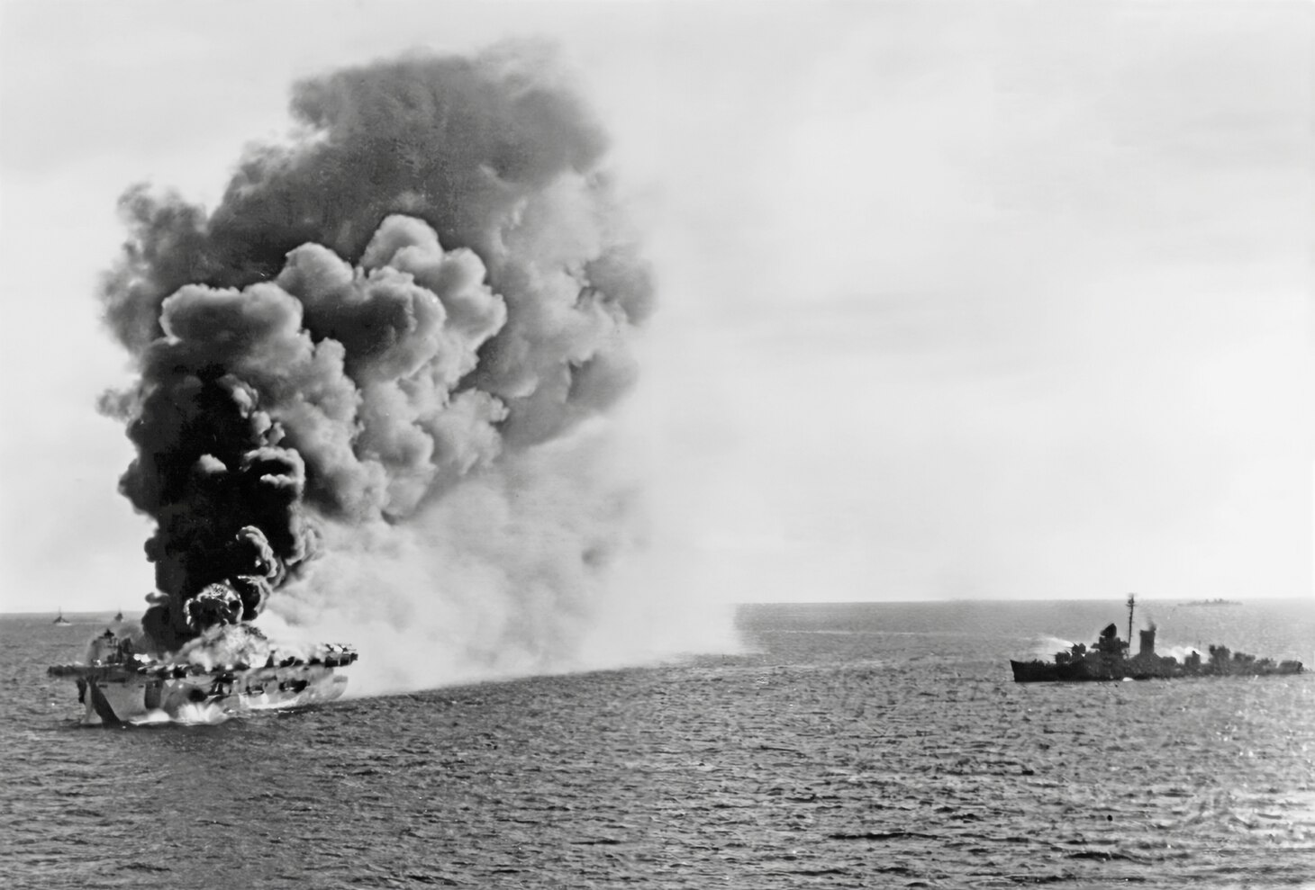Burning in the Sulu Sea, off Luzon, on Jan. 4, 1945, during the Lingayen Operation. She had been hit by a Kamikaze. A destroyer is standing by with fire hoses ready.