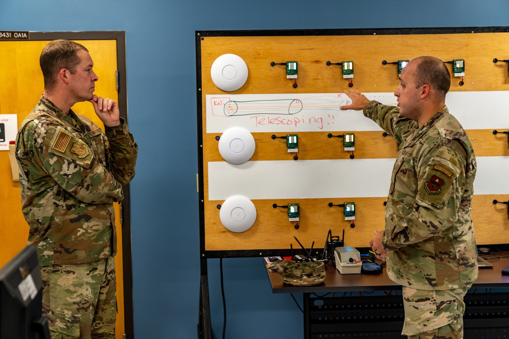 U.S. Air Force Chief Master Sgt. Michael Venning, 81st Training Wing command chief, receives a brief from Tech. Sgt. Jessie Ludlum, 333rd Training Squadron instructor, during an immersion tour with the 81st Training Group at Keesler Air Force Base, Mississippi, Aug. 1, 2023.