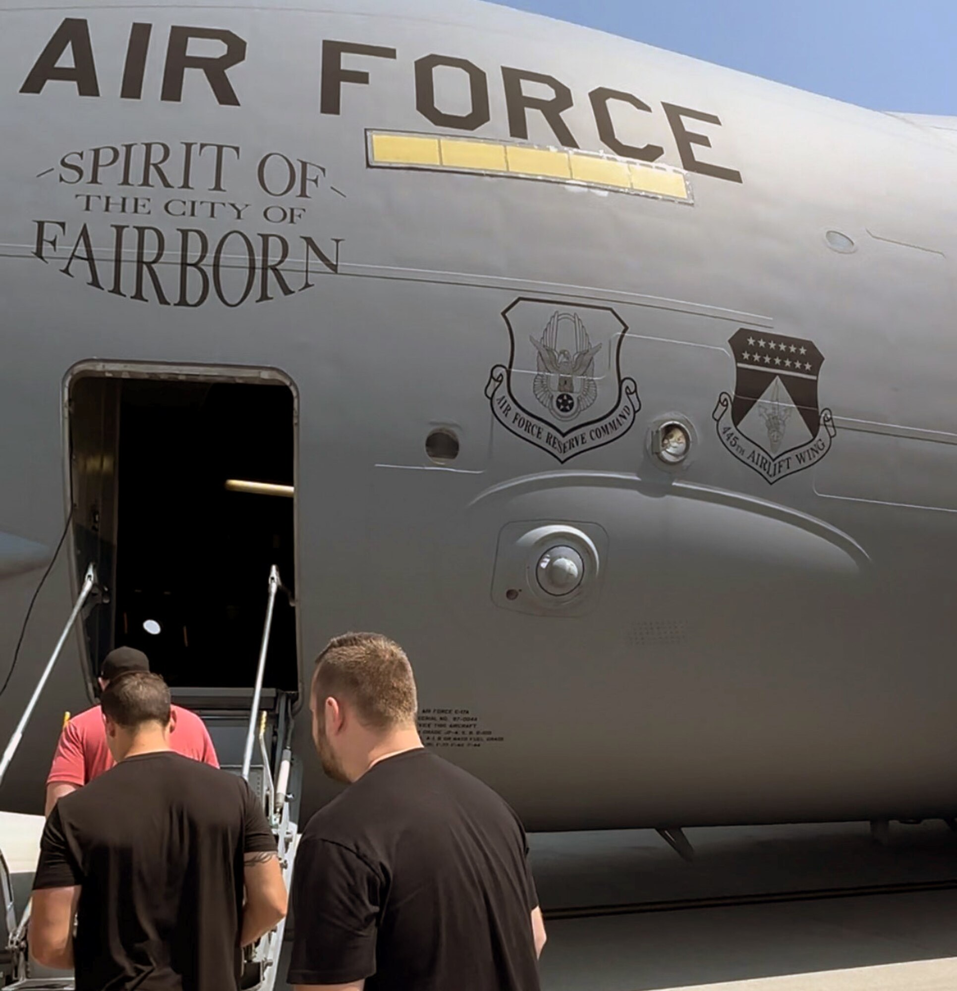 Rich Dotson, Matt O’Hara and Garret Price, DynastyNerds podcast, prepare to board a 445th Airlift Wing C-17 Globemaster III at Wright Patterson Air Force Base, Ohio, Aug. 23, 2023. The podcasters learned about the 445th Aeromedical Evacuation Squadron mission as part of their visit to the base and wing. (U.S. Air Force photo by 445th Airlift Wing Public Affairs)(Photo taken with phone)