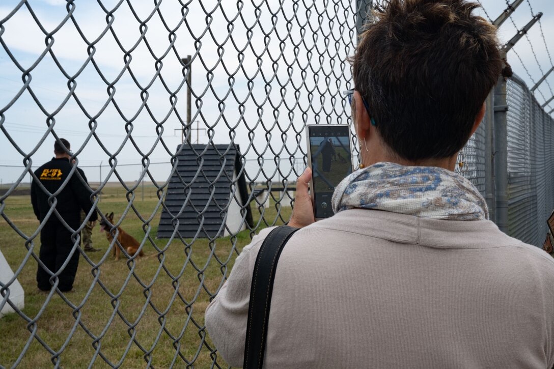 Mary Gilbertson-Lee, the 28th Operational Medical Readiness Squadron honorary commander, watches a 28th Security Forces Squadron military working dog demonstration during an honorary commander base tour at Ellsworth Air Force Base, South Dakota, August 25, 2023.