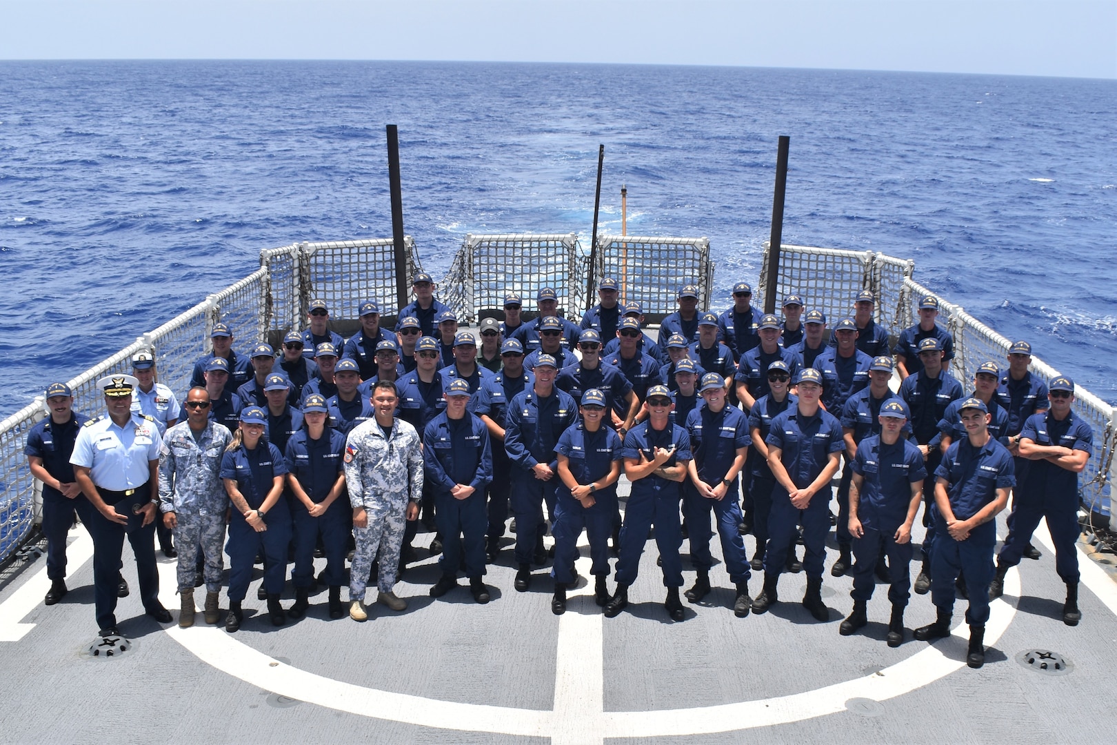 Coast Guardsman assigned to the U.S. Coast Guard Cutter Resolute (WMEC 620) attend a quarters meeting on the flight deck during a patrol in the Windward Passage supporting Operation Vigilant Sentry, July 1, 2023. At quarters, the Resolute introduced newly reported crew members and promoted the unit's Executive Officer, Cmdr. Mario Gil, to the rank of Commander. (U.S. Coast Guard photo by Petty Officer 1st Class David Deal)