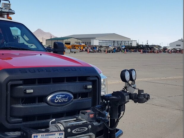 A military fire vehicle stands ready on the flight line.