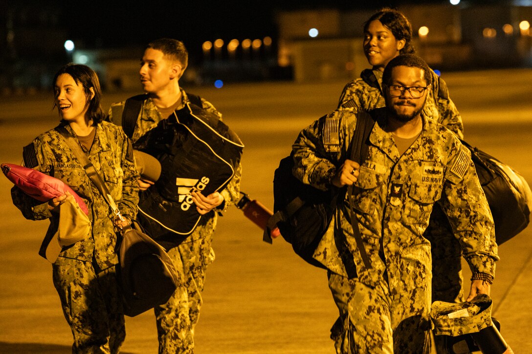 U.S. Navy Sailors with Carrier Air Wing (CVW) 5 walk across the flightline after returning to Marine Corps Air Station, Iwakuni, Japan, August 25, 2023. The air wing's return marked the completion of their most recent deployment aboard the USS Ronald Reagan (CVN-76), where they provided airpower to protect U.S. forces and allies as they flew missions in support of a free and open Indo-Pacific. (U.S. Marine Corps photo by Lance Cpl. Micah Taylor)