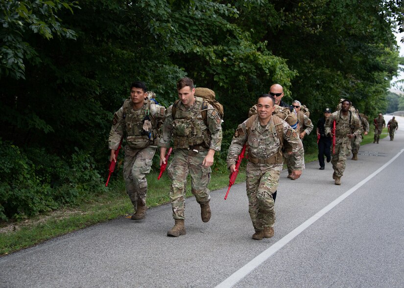 Military members run on a road.
