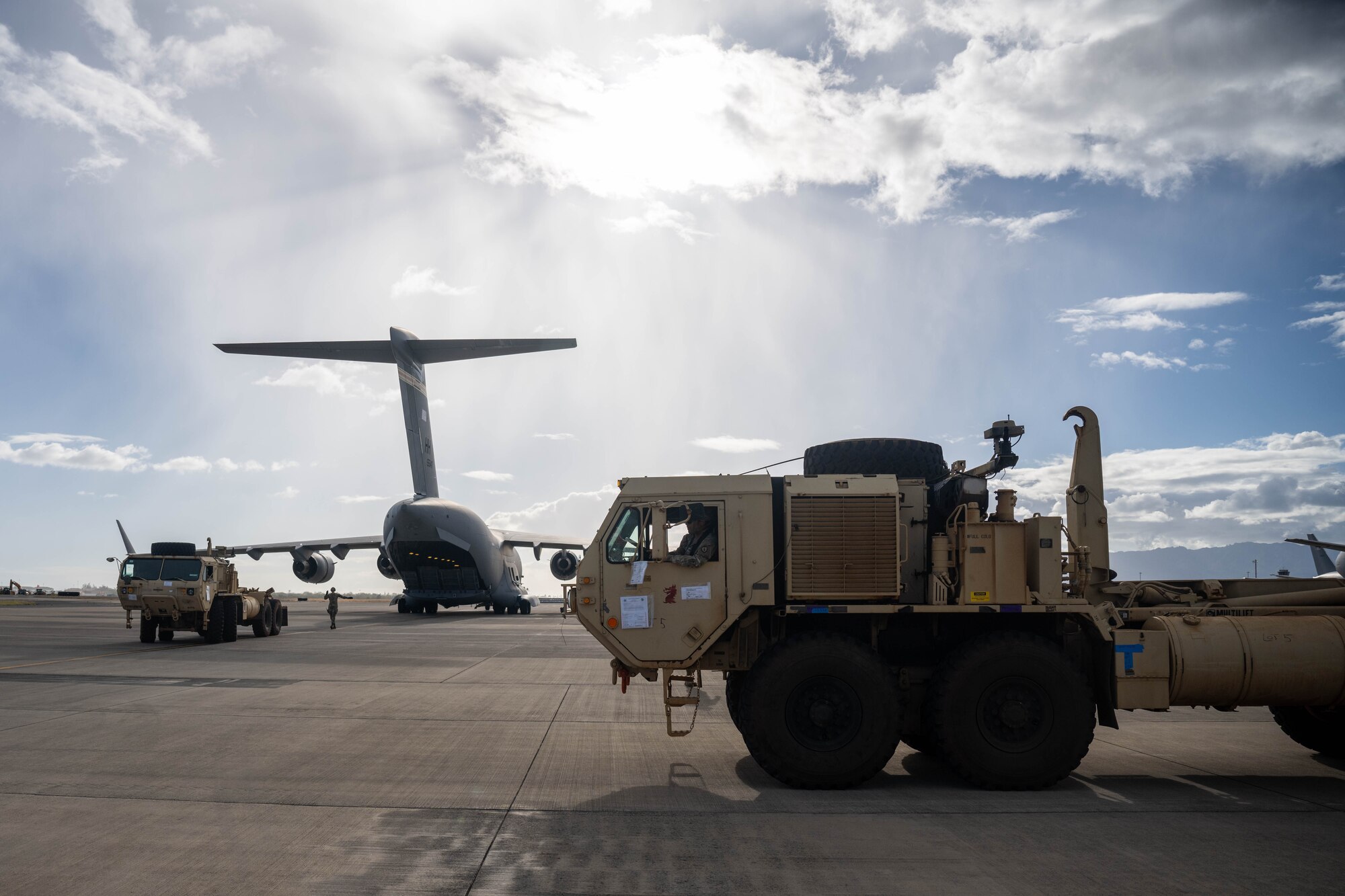 U.S. Army Soldiers drive two Oshkosh Palletized Load Systems onto a C-17 Globemaster III in support of the Maui wildfire recovery efforts at Joint Base Pearl Harbor-Hickam, Hawaii, August 27, 2023. Airmen and Soldiers from the 535th AS and 225th Brigade Support Battalion delivered equipment and resources to Joint Task Force-50 to help the communities affected by the wildfires in Maui. (U.S. Air Force photo by Senior Airman Makensie Cooper)