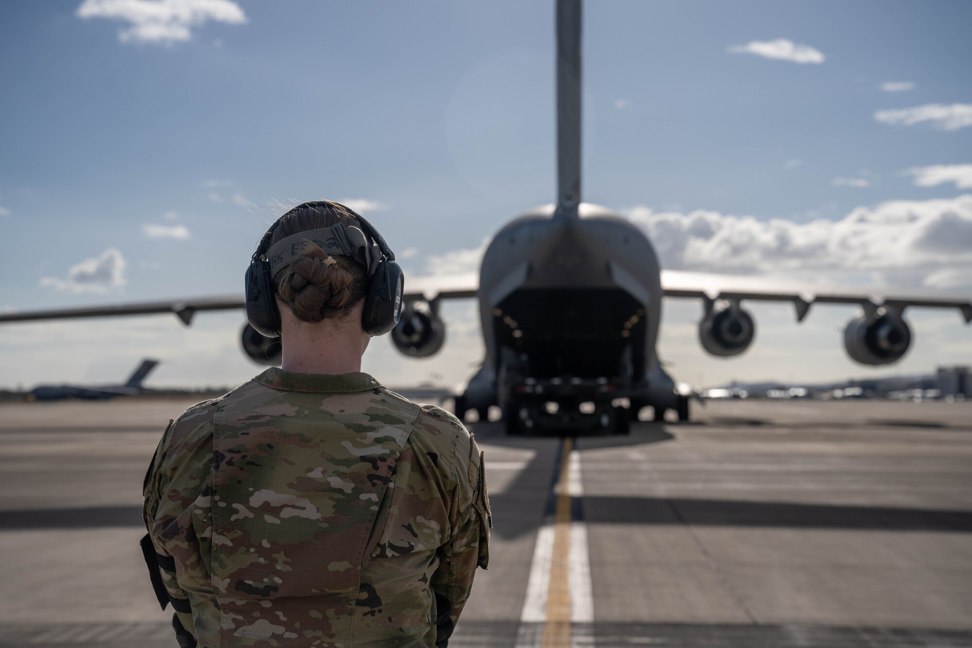 U.S. Airman 1st Class Laura Innes, 735th Air Mobility Squadron cargo specialist, observes the loading of cargo on a C-17 Globemaster III in support of Maui wildfire recovery at Joint Base Pearl Harbor-Hickam, Hawaii, August 27, 2023. Airmen from the 535th Airlift Squadron and 735th AMS transported equipment and resources to Joint Task Force 50 to help the communities affected by the wildfires in Maui. (U.S. Air Force photo by Senior Airman Makensie Cooper)