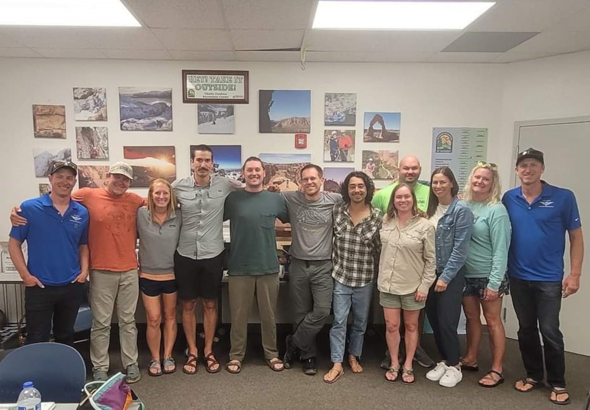 12 people gather together and smile for the camera