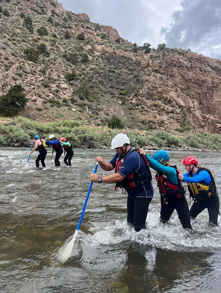 teams of three use a paddle to walk out of rough water