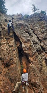 two participants on the face of a rock