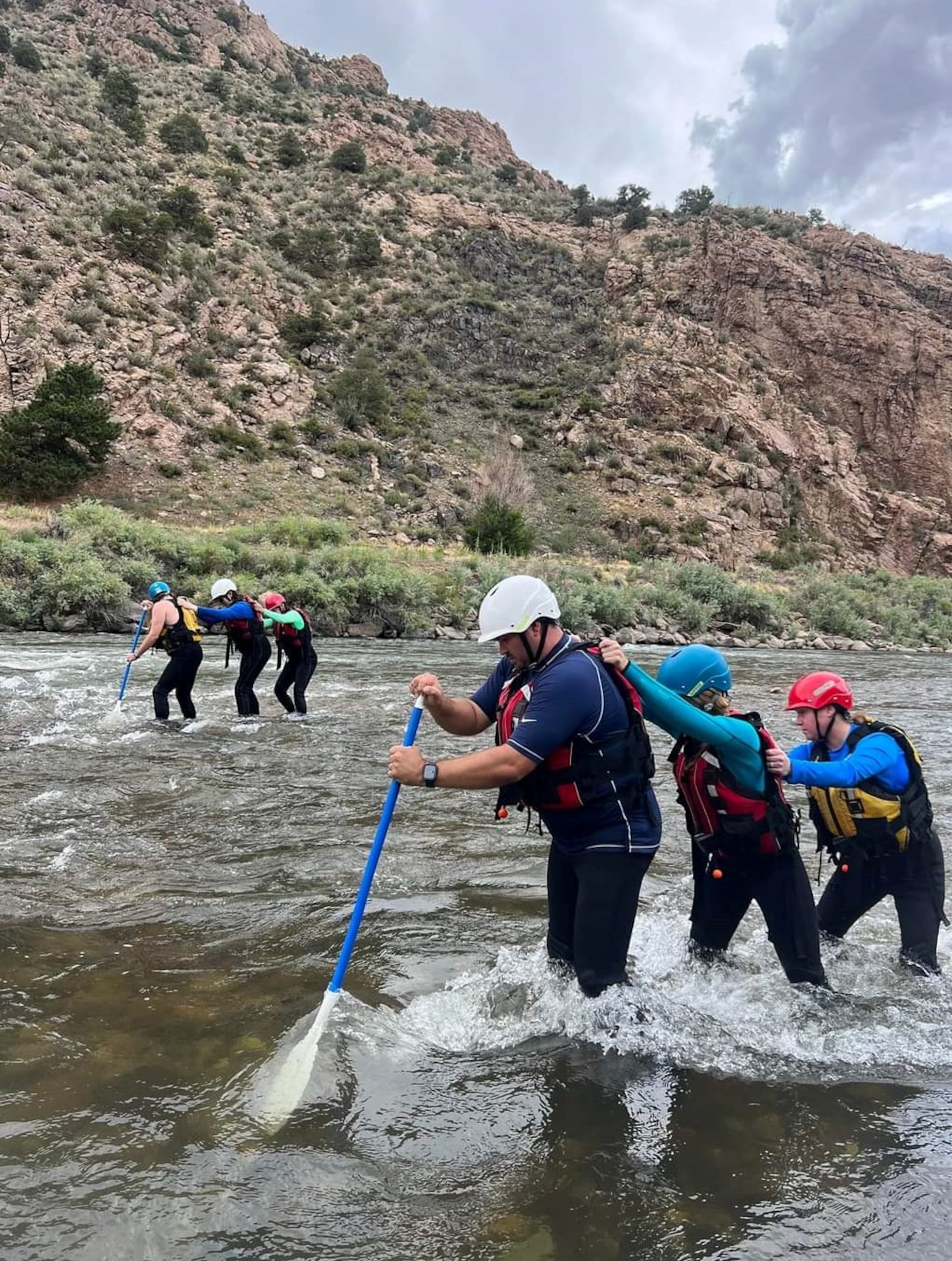 teams of three use a paddle to walk out of rough water