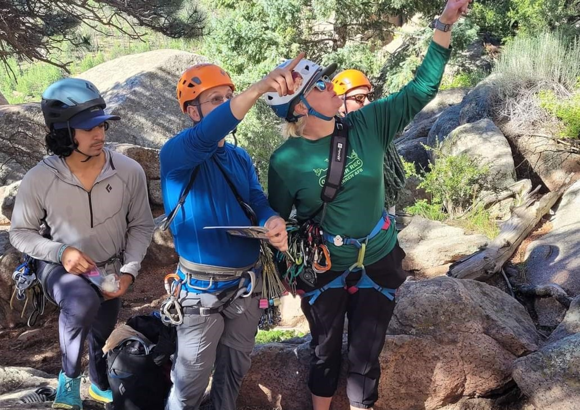 participants point to different approaches on a rock face