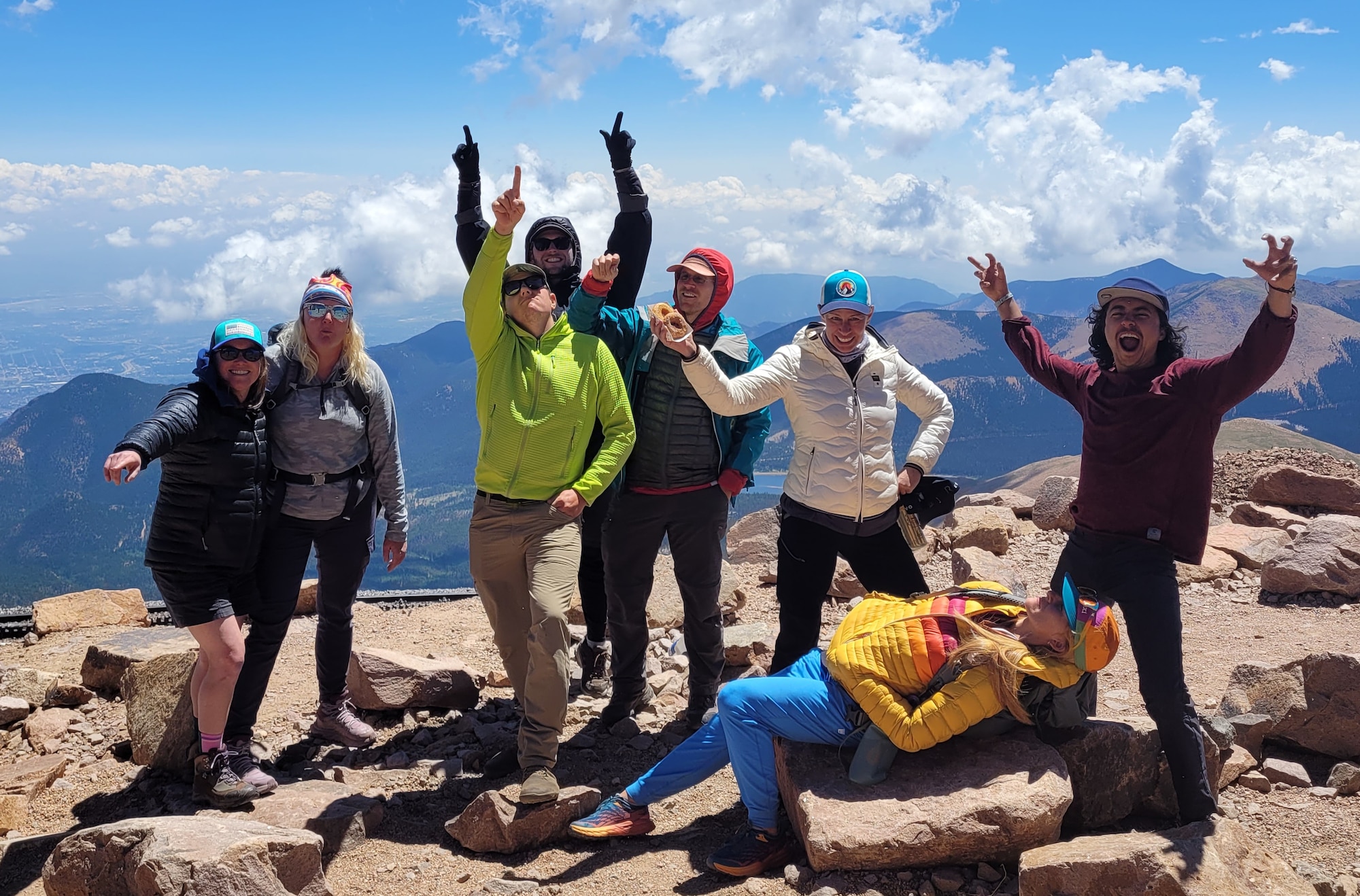 eight people pose for a fun photo with mountains in the background