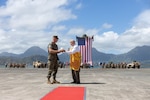 U.S. Marine Corps Lt. Col. Heath Phillips, commanding officer, 1st Low Altitude Air Defense (LAAD) Battalion, Marine Air Control Group 18, 1st Marine Aircraft Wing, receives a gift during a reactivation and designation ceremony at Marine Corps Air Station Kaneohe Bay, Hawaii, Aug. 31, 2023. Originally activated in July 1982 in Okinawa, Japan, the unit underwent two redesignations before folding its’ colors in Sept. 2007. The reactivation of 1st LAAD Battalion demonstrates forward progression toward force modernization in the INDOPACIFIC region. The primary mission of 1st LAAD Battalion is to deliver close-in, low-altitude, surface-to-air weapon capabilities. (U.S. Marine Corps photo by Lance Cpl. Clayton Baker)