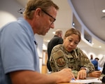 A clinical nurse and emergency flight commander brainstorm at a table.