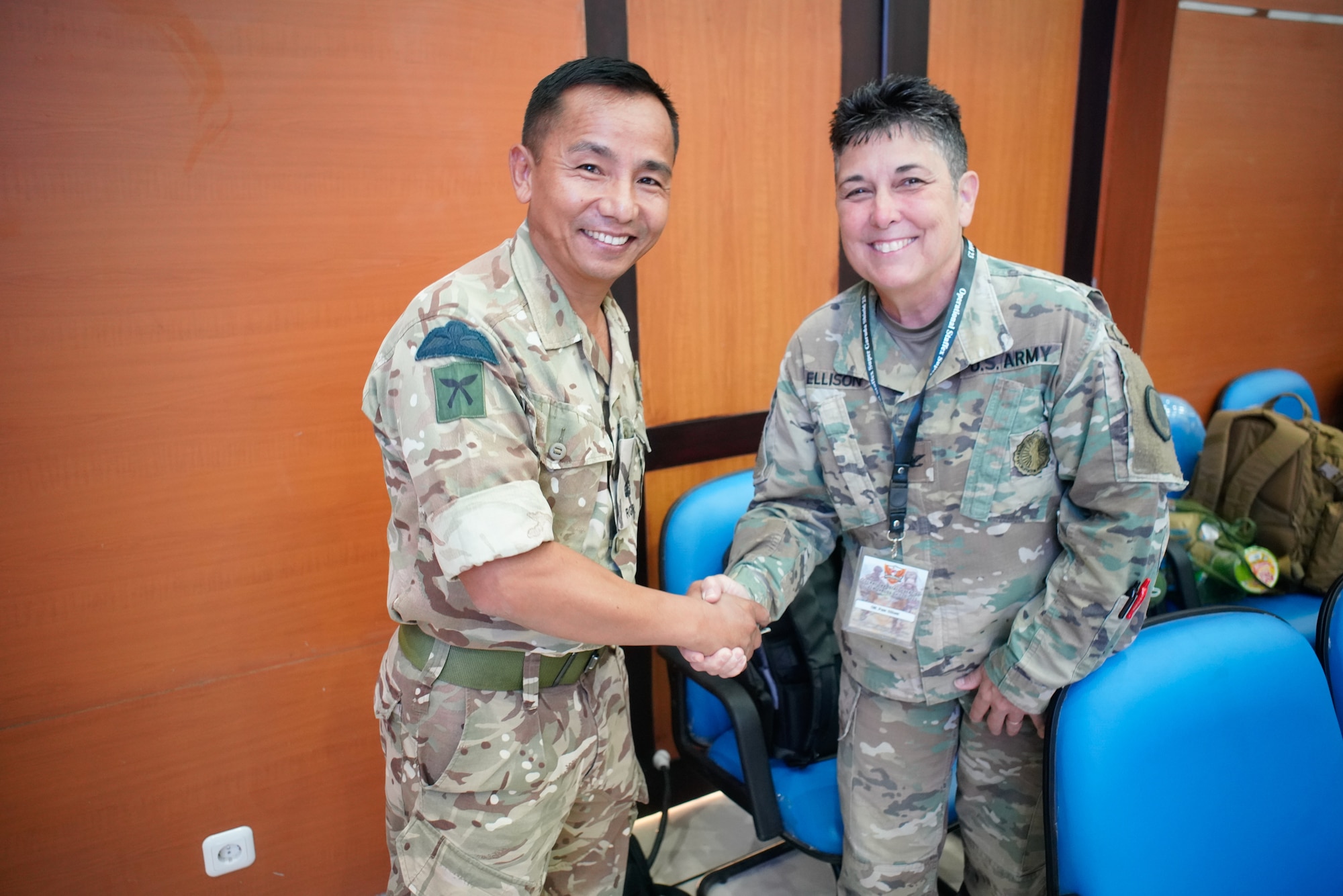Maj Som Thulung, United Kingdom Armed Forces delegation, and Col. Pam Ellison, Hawaii Army National Guard, U.S. Armed Forces delegation, greet each other before the opening ceremony of the staff exercise portion of Super Garuda Shield 2023 on Aug. 31 in Surabaya Indonesia. The annual exercise has grown in scope and size since 2009.
