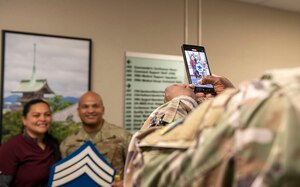 A U.S. Air Force Airman takes a photo of a U.S. Air Force Airman and spouse.