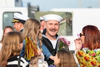 A Sailor assigned to the Arleigh Burke-class guided-missile destroyer USS Paul Ignatius (DDG 117) greets his family on the pier at Naval Station (NAVSTA) Rota as the ship returns from deployment, Nov. 28, 2023. As the "Gateway to the Mediterranean,” NAVSTA Rota provides U.S, NATO and allied forces a strategic hub for operations in Europe, Africa and the Middle East. NAVSTA Rota is a force multiplier, capable of promptly deploying and supporting combat-ready forces through land, air and sea, enabling warfighters and their families, sustaining the fleet and fostering the U.S. and Spanish partnership. (U.S. Navy photo by Mass Communication Specialist 2nd Class Drace Wilson)