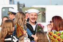 A Sailor assigned to the Arleigh Burke-class guided-missile destroyer USS Paul Ignatius (DDG 117) greets his family on the pier at Naval Station (NAVSTA) Rota as the ship returns from deployment, Nov. 28, 2023. As the "Gateway to the Mediterranean,” NAVSTA Rota provides U.S, NATO and allied forces a strategic hub for operations in Europe, Africa and the Middle East. NAVSTA Rota is a force multiplier, capable of promptly deploying and supporting combat-ready forces through land, air and sea, enabling warfighters and their families, sustaining the fleet and fostering the U.S. and Spanish partnership. (U.S. Navy photo by Mass Communication Specialist 2nd Class Drace Wilson)