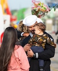 A Sailor assigned to the Arleigh Burke-class guided-missile destroyer USS Paul Ignatius (DDG 117) greets his family on the pier at Naval Station (NAVSTA) Rota as the ship returns from deployment, Nov. 28, 2023. As the "Gateway to the Mediterranean,” NAVSTA Rota provides U.S, NATO and allied forces a strategic hub for operations in Europe, Africa and the Middle East. NAVSTA Rota is a force multiplier, capable of promptly deploying and supporting combat-ready forces through land, air and sea, enabling warfighters and their families, sustaining the fleet and fostering the U.S. and Spanish partnership. (U.S. Navy photo by Mass Communication Specialist 2nd Class Drace Wilson)