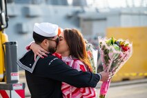 A Sailor assigned to the Arleigh Burke-class guided-missile destroyer USS Paul Ignatius (DDG 117) greets his family on the pier at Naval Station (NAVSTA) Rota as the ship returns from deployment, Nov. 28, 2023. As the "Gateway to the Mediterranean,” NAVSTA Rota provides U.S, NATO and allied forces a strategic hub for operations in Europe, Africa and the Middle East. NAVSTA Rota is a force multiplier, capable of promptly deploying and supporting combat-ready forces through land, air and sea, enabling warfighters and their families, sustaining the fleet and fostering the U.S. and Spanish partnership. (U.S. Navy photo by Mass Communication Specialist 2nd Class Drace Wilson)