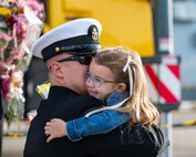 A Sailor assigned to the Arleigh Burke-class guided-missile destroyer USS Paul Ignatius (DDG 117) greets his family on the pier at Naval Station (NAVSTA) Rota as the ship returns from deployment, Nov. 28, 2023. As the "Gateway to the Mediterranean,” NAVSTA Rota provides U.S, NATO and allied forces a strategic hub for operations in Europe, Africa and the Middle East. NAVSTA Rota is a force multiplier, capable of promptly deploying and supporting combat-ready forces through land, air and sea, enabling warfighters and their families, sustaining the fleet and fostering the U.S. and Spanish partnership. (U.S. Navy photo by Mass Communication Specialist 2nd Class Drace Wilson)
