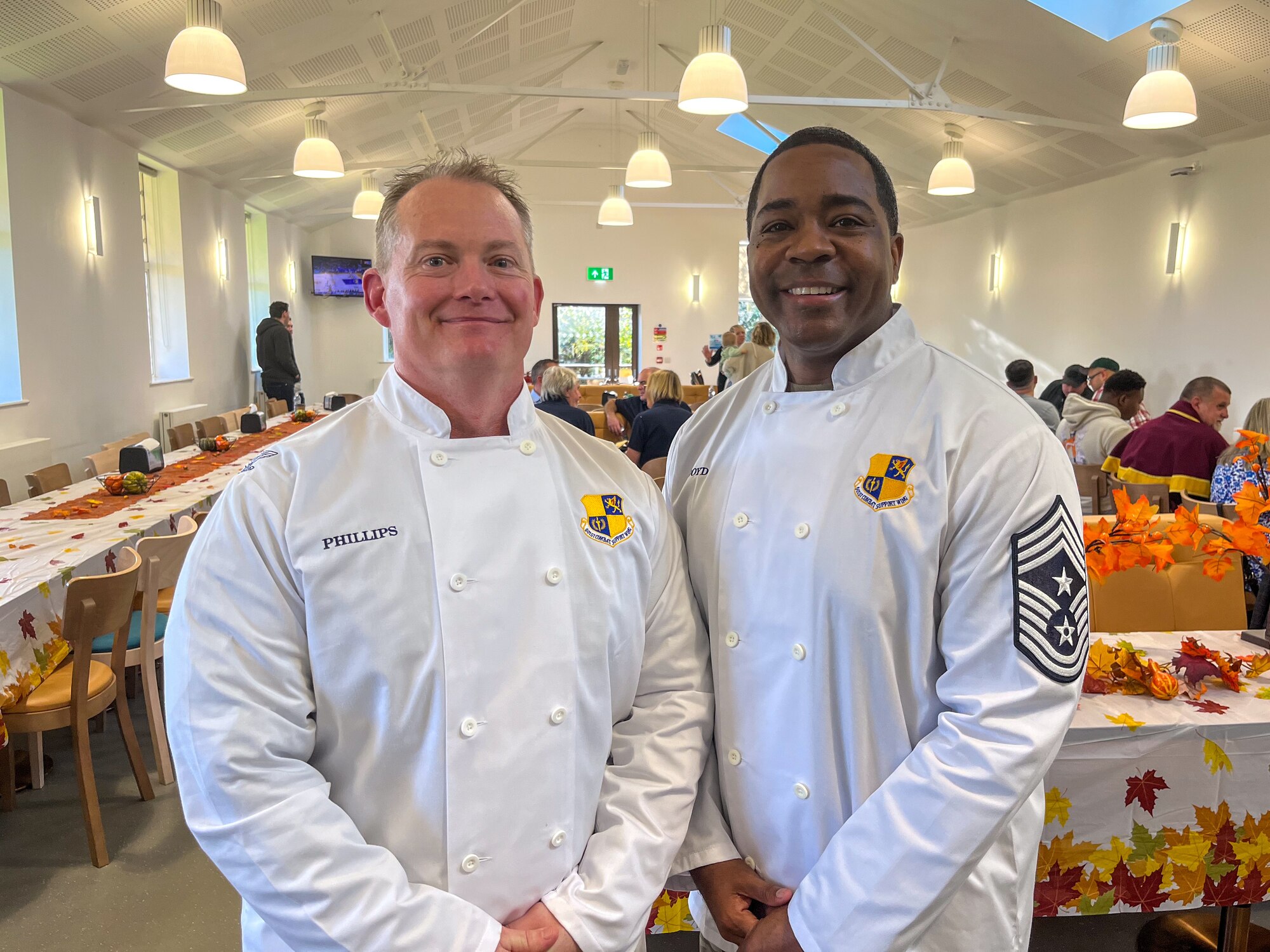 Leadership pose for a photo while wearing custom chef coats.